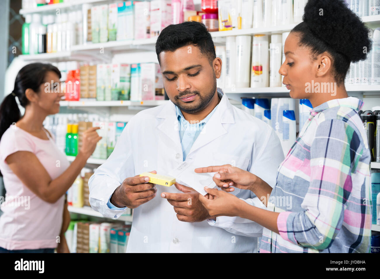 Kunden- und Chemiker mit Rezept In Apotheke Stockfoto