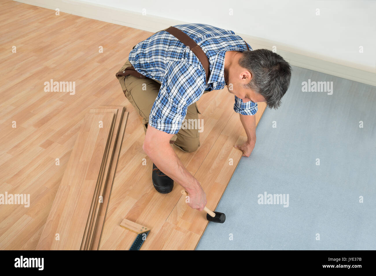 Hohe Betrachtungswinkel eines Arbeitnehmers Montage neuer Laminatboden Stockfoto