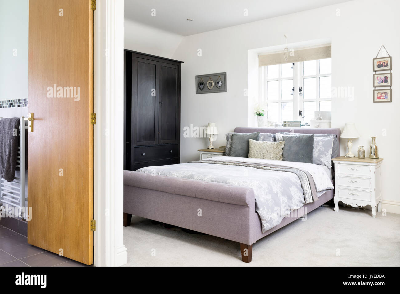 Ein King Bett in einem modernen Doppelzimmer mit en-suite Bad ausgestattet. Stockfoto