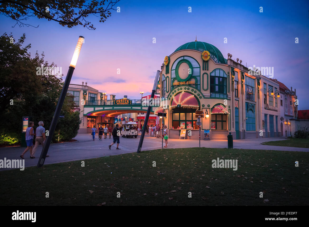 Vergnügungspark mit Riesenrad in Aktion in der Abenddämmerung mit Licht an in Wien, Österreich, Europa. Stockfoto