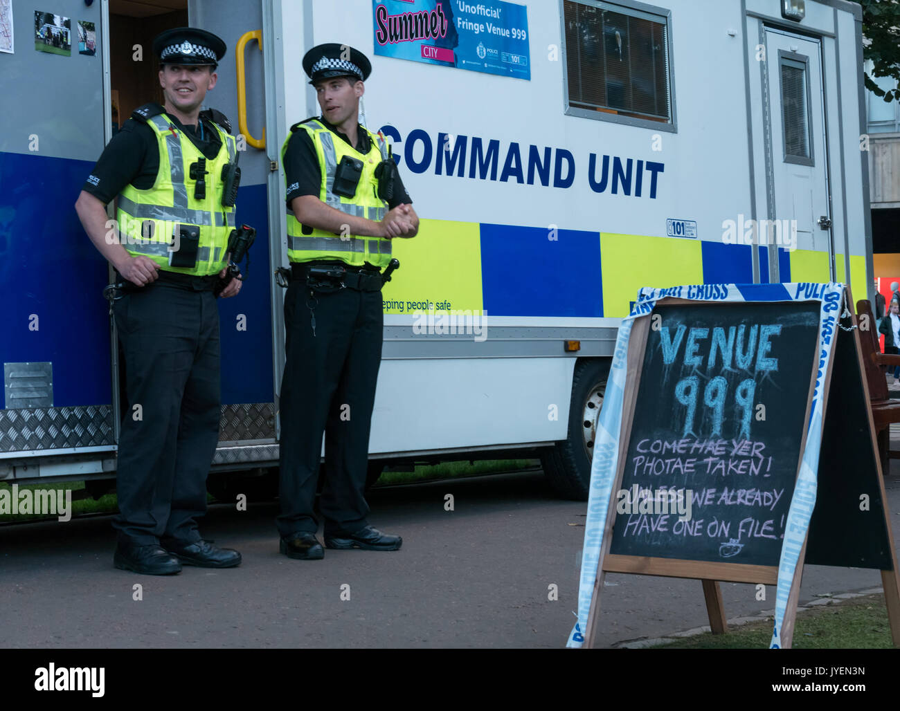 Polizei Schottland Command Einheit, Princes Street Gardens beim Edinburgh Fringe Festival und humorvoll Schiefertafel Zeichen, Veranstaltungsort 999, mit zwei Polizisten Stockfoto