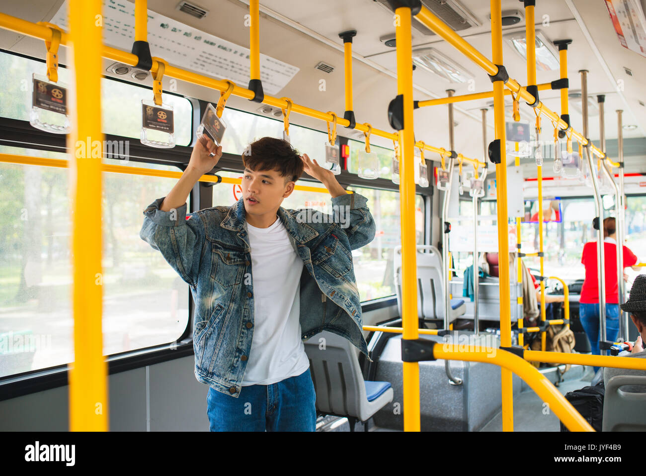 Asiatischer Mann mit den öffentlichen Verkehrsmitteln, Bus stehen. Stockfoto