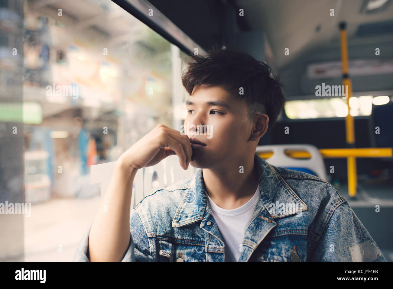 Asiatischer Mann reisender Betrachtung im freien Blick aus dem Fenster der Bahn oder Bus. Stockfoto