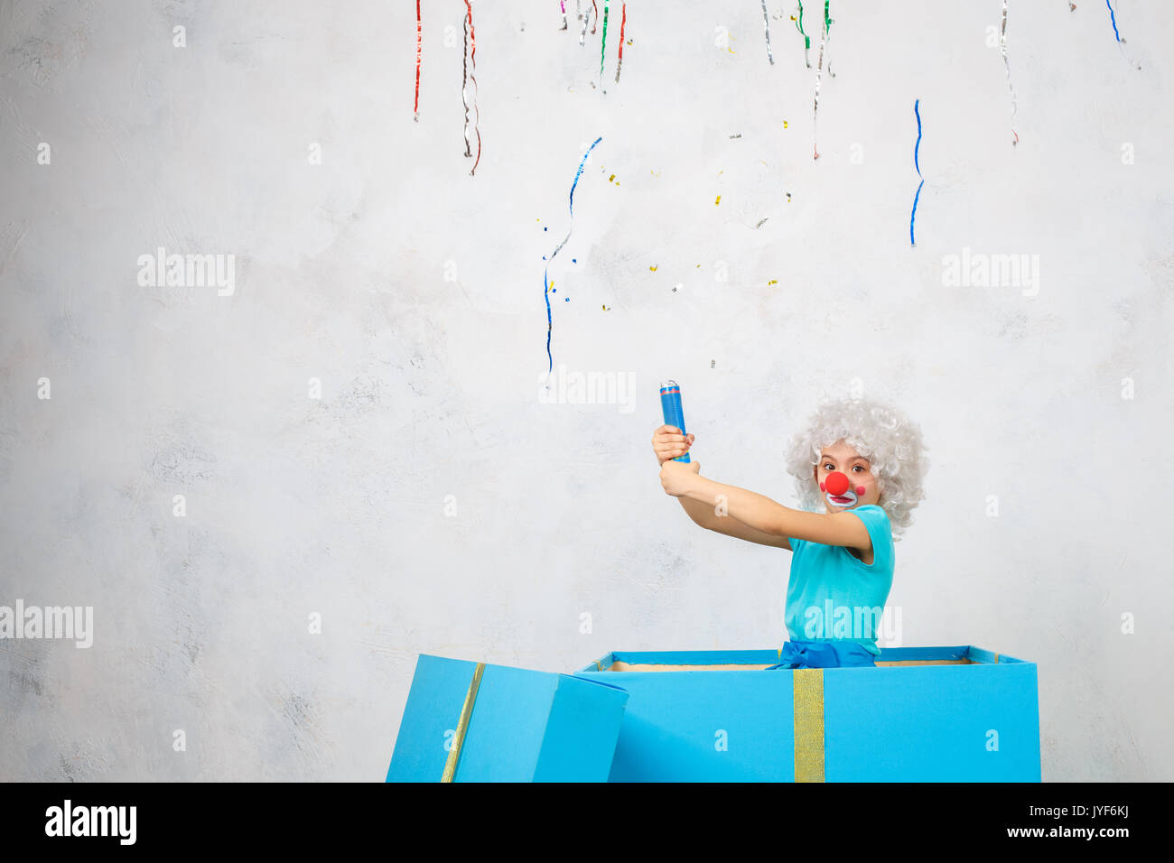 Kleines Kind tragen Clown Kostüm Geburtstagsfeier in einer Geschenkbox Stockfoto