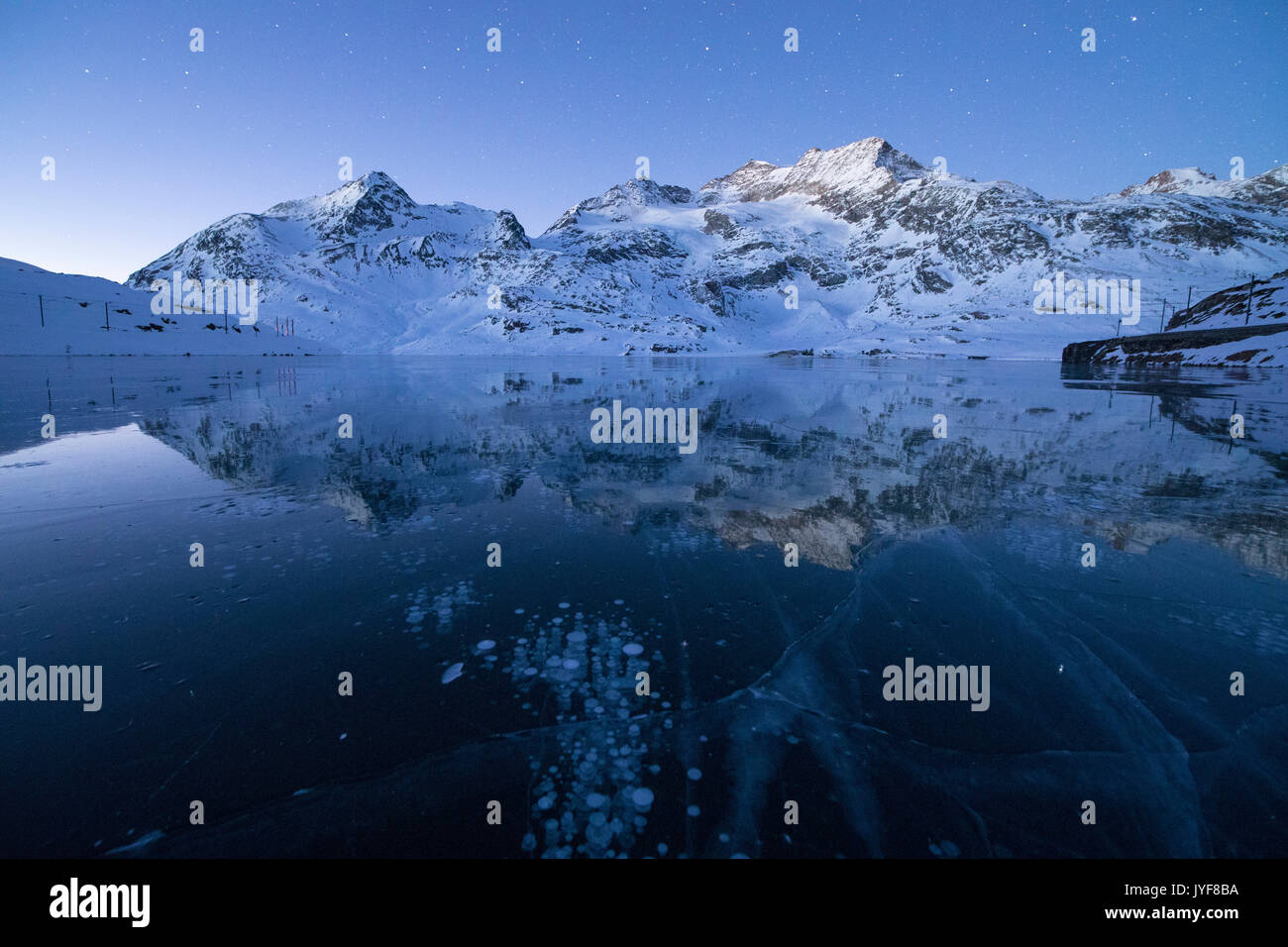 Eis blasen Frame die schneebedeckten Gipfel in Lago Bianco Berninapass Kanton Graubünden Engadin Schweiz Europa wider Stockfoto