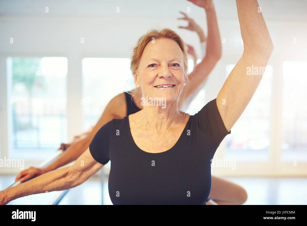 Ältere weibliche balletdancer mit Hand im Stehen, und wenn man die Kamera während einer Übung in der Klasse. Stockfoto