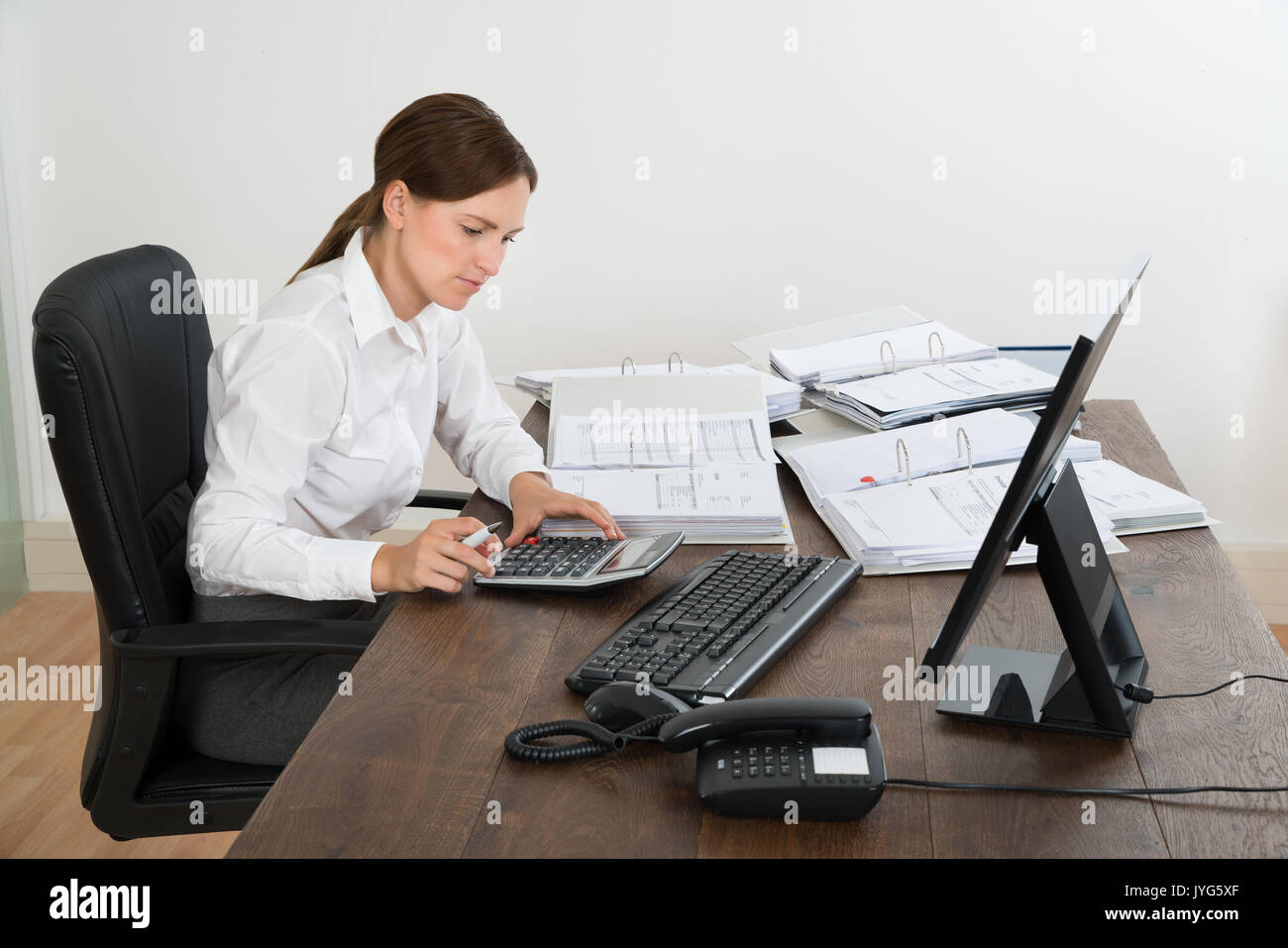 Junge weibliche Buchhalter, Berechnung mit dem Rechner am Schreibtisch Stockfoto