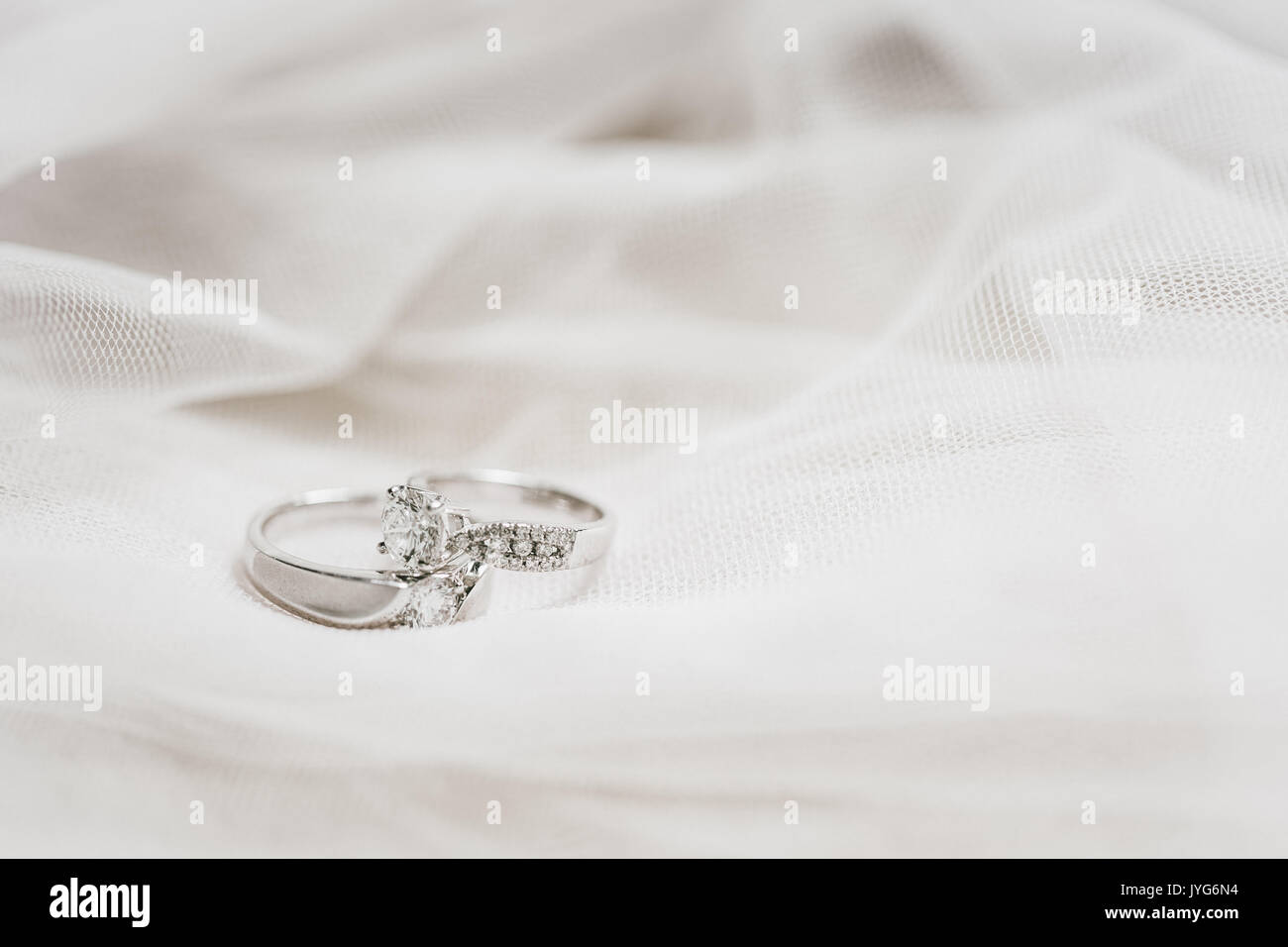 Zwei Trauringe auf einem weißen Tuch Stockfoto