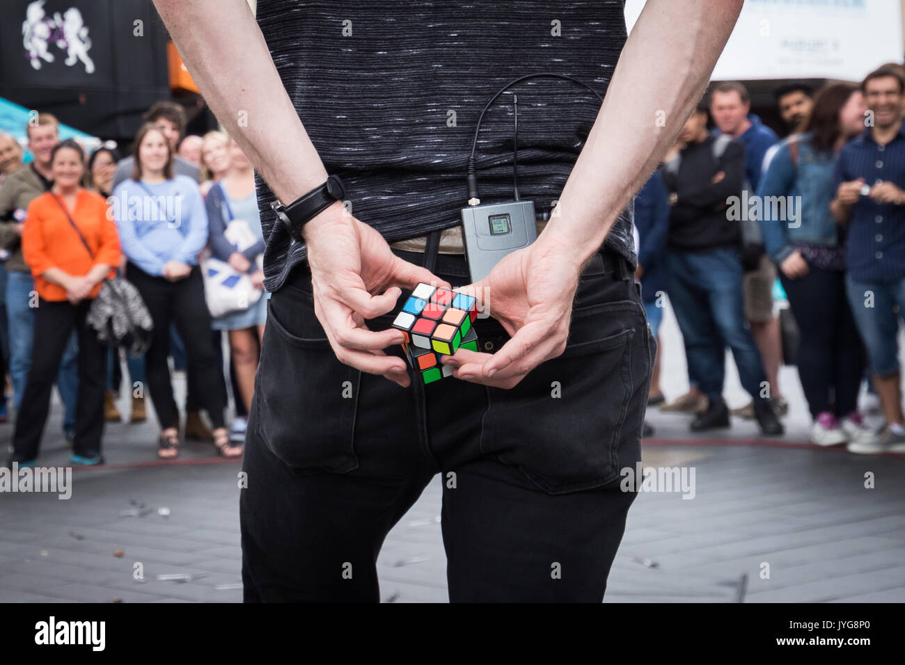 Eine Straße Magier Interpret unterhält Touristen in der Londoner Leicester Square durch Ausfüllen eines Rubik's Cube puzzle hinter seinem Rücken innerhalb von wenigen Sekunden. Stockfoto