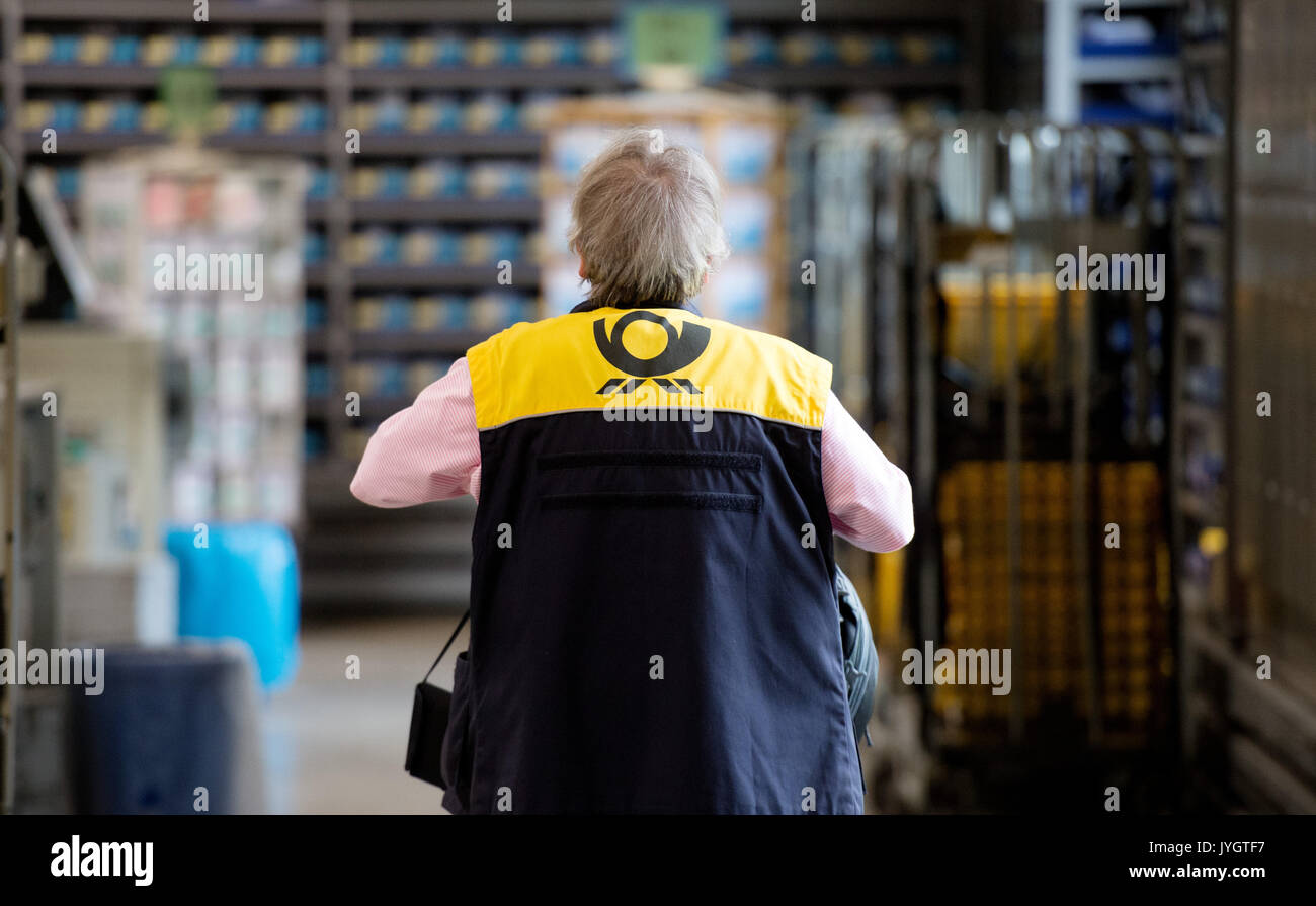 Ein Mitarbeiter der Deutschen Post AG (Deutsche Post) arbeitet im Briefzentrum Altona in Hamburg, Deutschland, 18. August 2017. Foto: Daniel Reinhardt/dpa Stockfoto