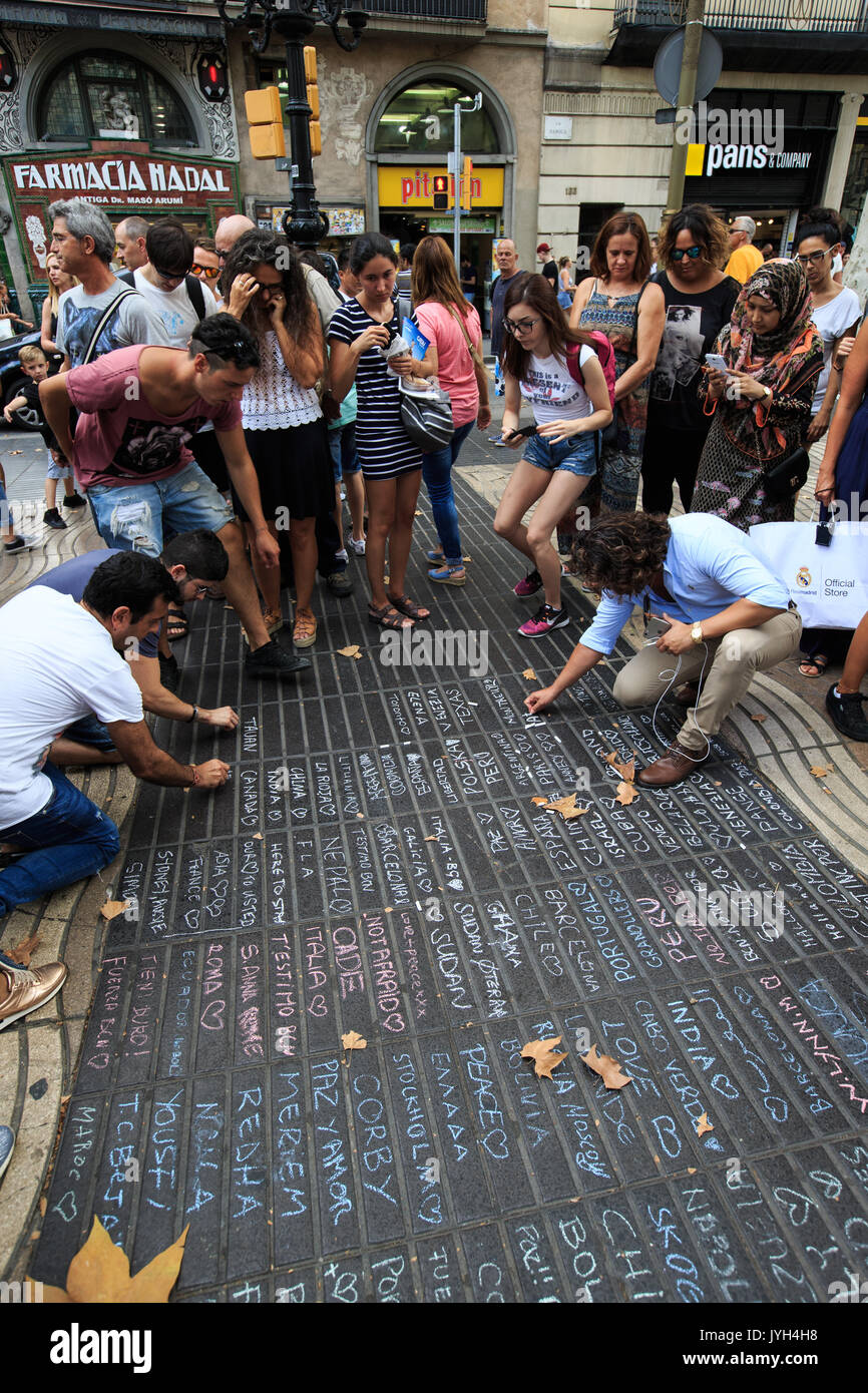 Barcelona, Spanien. 19 Aug, 2017. Die Leute gehen weg, Nachrichten mit Kreiden für die Opfer der Terroranschläge auf die Avenue in der Las Ramblas von Barcelona, Spanien, August 19, 2017 zu beklagen. Die spanische Regierung hat beschlossen, seine anti-terror Alert Level 4 zu erhalten, sondern versprach Sicherheit Maßnahmen gleichzeitig zu verstärken, das Innenministerium sagte am Samstag in einer Erklärung. Insgesamt 14 Tote bei zwei Anschlägen in den spanischen Städten Barcelona und Cambrils, die auch ungefähr 126 Menschen aus 34 verschiedenen Nationalitäten Schaden aufgetreten ist. Credit: Xu Jinquan/Xinhua/Alamy leben Nachrichten Stockfoto