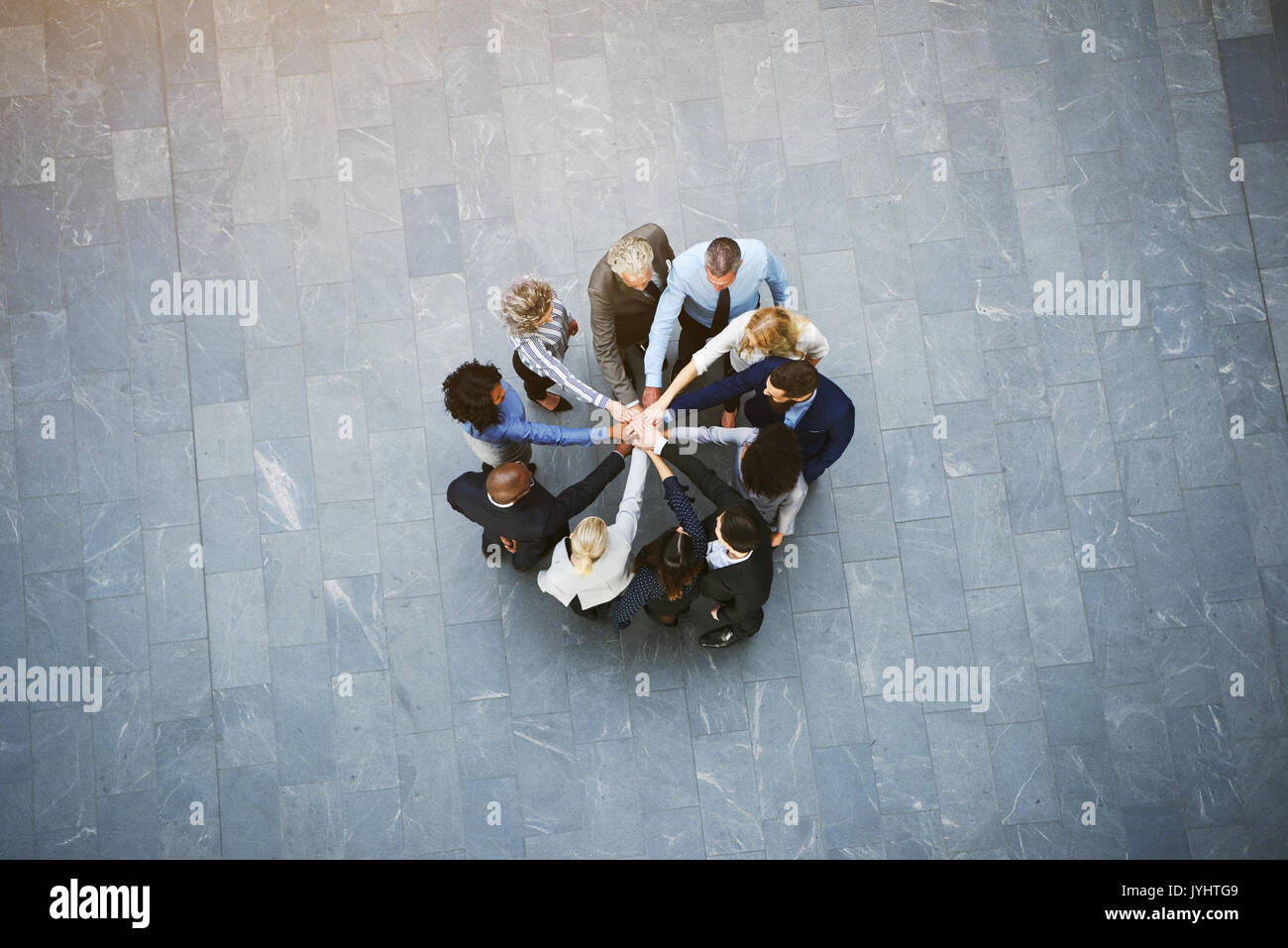 Von oben schwarz und weiß Business Leute, Teambuilding in der Halle des Ständigen mit Händen gestapelt. Stockfoto