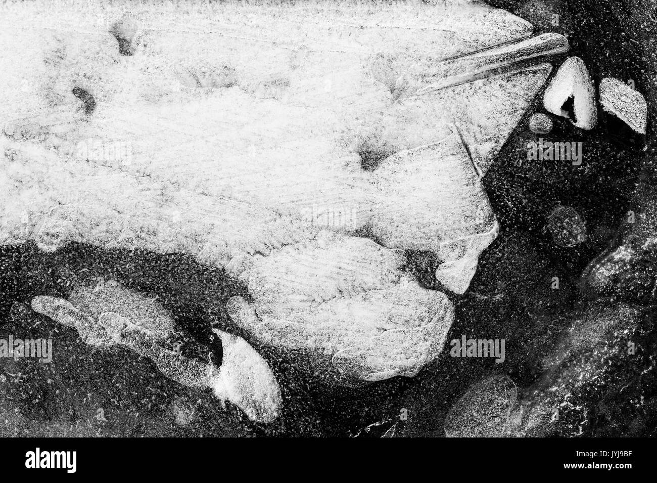 Gefrorene Pfützen, Eismuster und abstrakte Bilder sowie die Designs der Natur Stockfoto