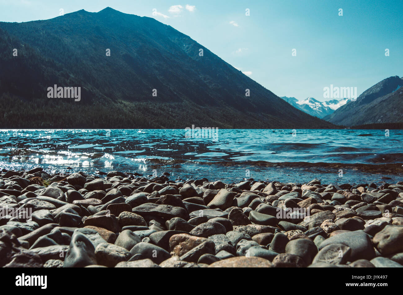 Kristallklare Pebble Stones und die wunderschönen tropischen See in den Bergen. Große runde Kieselsteine auf dem See im Vordergrund. Stockfoto