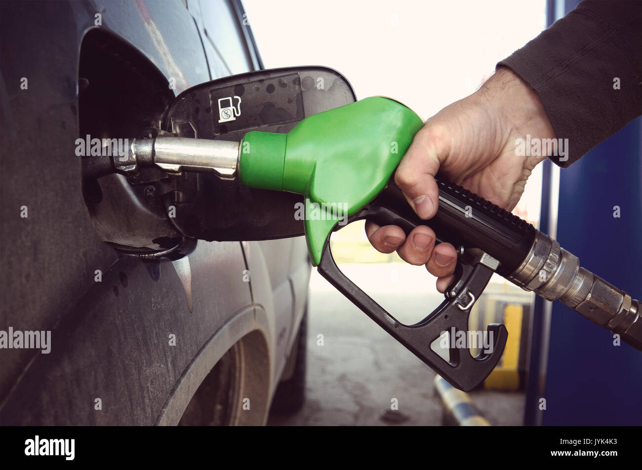 Kraftstoff auffüllen an der Tankstelle. Füllen ein schmutziges Auto an einer Tankstelle. Füllkupplung zur Betankung ein Auto in der Hand des Menschen. Stockfoto