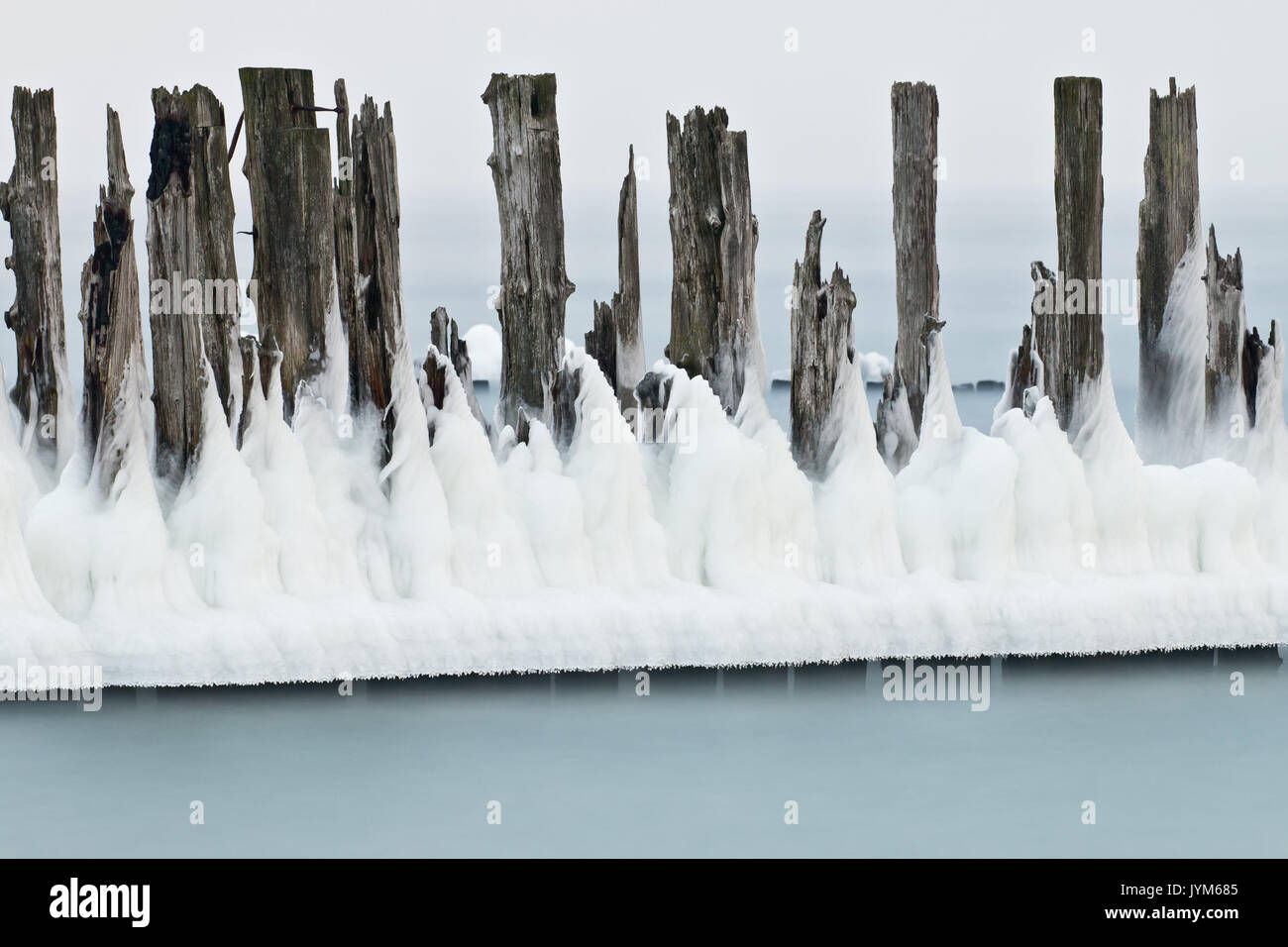 Die Eiskappen auf alten Holzpfählen im Einklang und Ruinen von Torpedo Gebäude Stockfoto