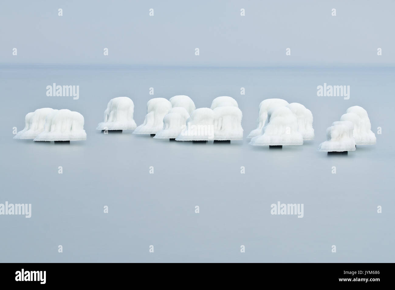Die Eiskappen auf alten Holzpfählen im Einklang und Ruinen von Torpedo Gebäude Stockfoto