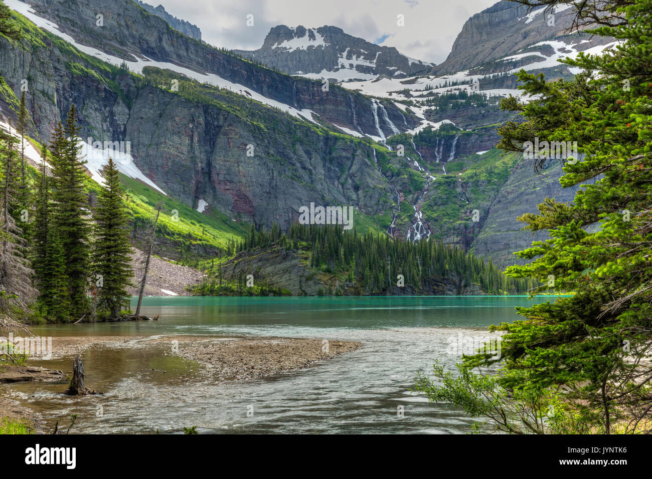 Ein Wasserfall fließt vom Grinnell Glacier in türkisblaue See in Grinnell Glacier National Park, Montana Stockfoto