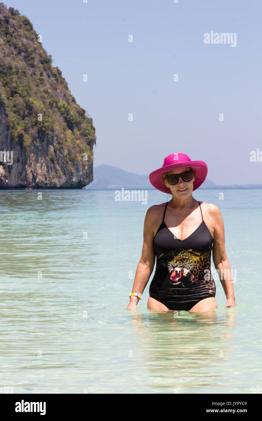 Ältere Frau mit rosa Hut im Meer, Koh Lao Liang, Trang, Thailand Stockfoto