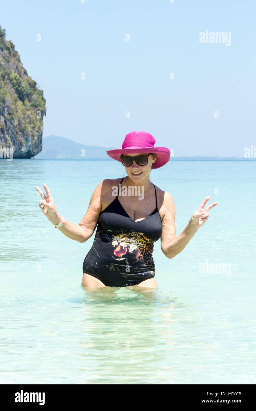 Ältere Frau mit rosa Hut im Meer, Koh Lao Liang, Trang, Thailand Stockfoto