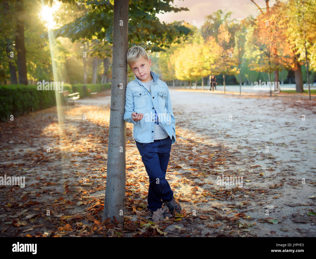 Cute boy steht im Herbst Baum Stockfoto
