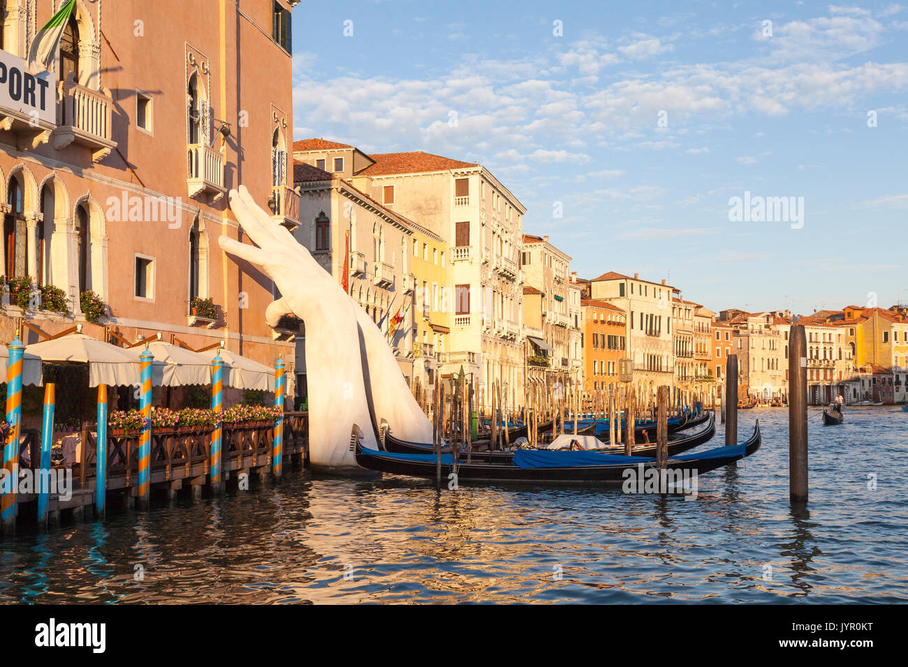 Sonnenuntergang auf dem Canal Grande, Venedig, Italien mit Lorenzo Quinn unterstützen mit den Händen unterstützen Ca'Sagredo Hotel und Gondeln. Das italienische a Stockfoto