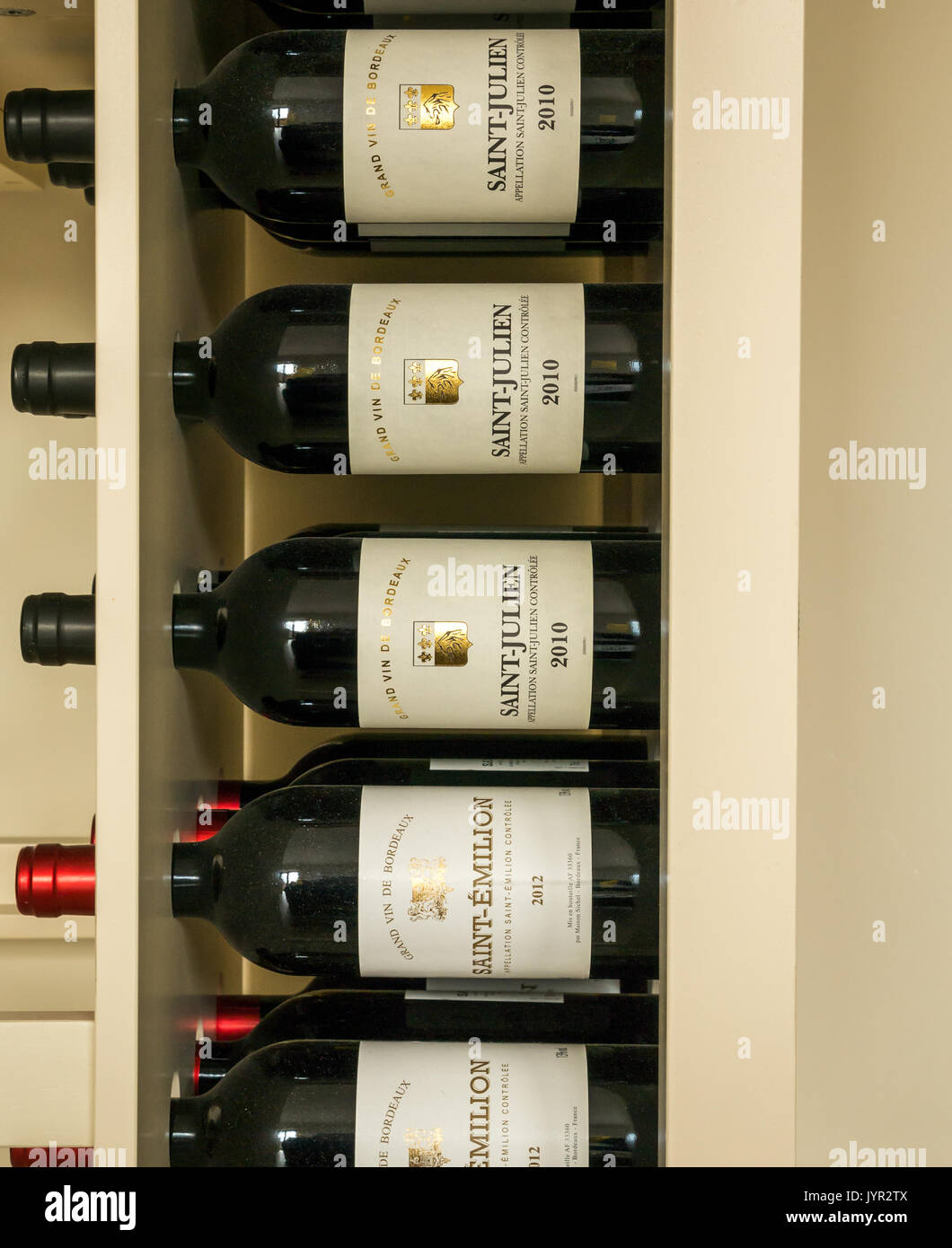 Rotwein Flaschen in einem Rack aus der Region Bordeaux in Frankreich, einschließlich Saint Julien und Saint Emilion. Stockfoto