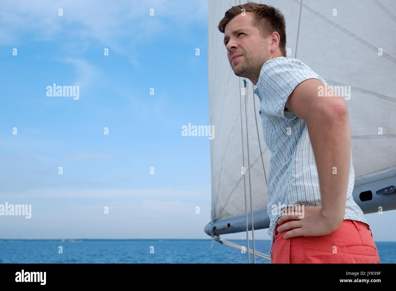 Junge kaukasier Sailor gerne entspannen auf Segelboot Yacht. Er loooks beiseite und Traum. Stockfoto