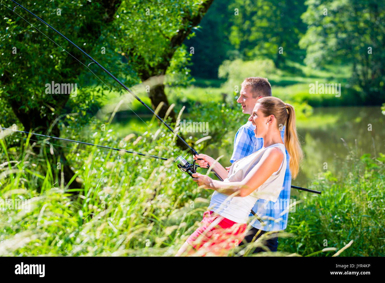 Angeln Mann und Frau zusammen mit Rod am Fluss Stockfoto