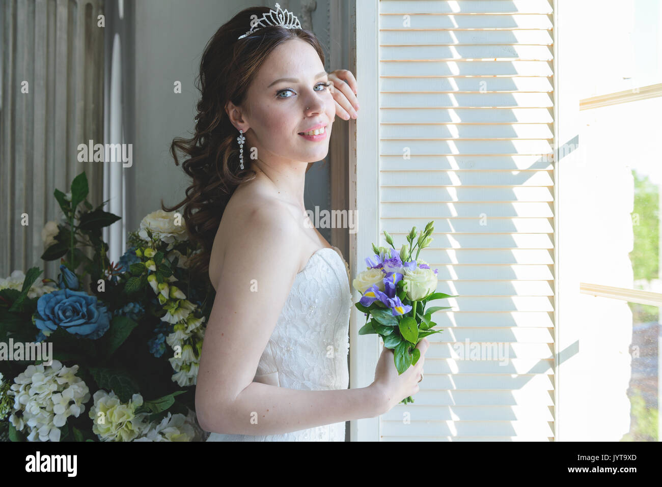 Junge attraktive Braut auf Brautkleid im Studio Stockfoto