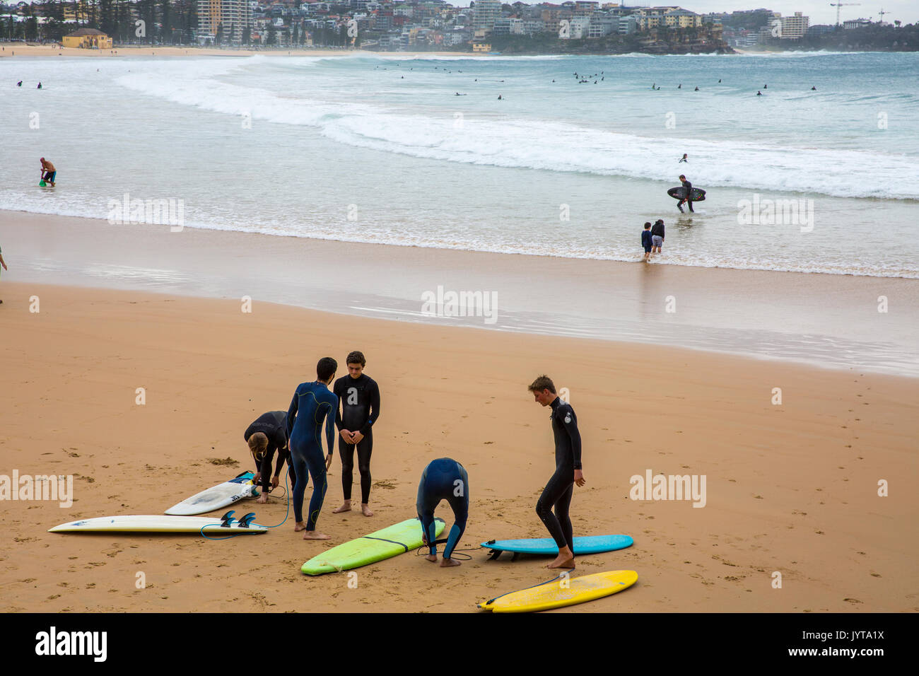 Junge Männer Surfer mit Surfbrettern auf Manly Beach im Winter, Sydney, Australien Stockfoto