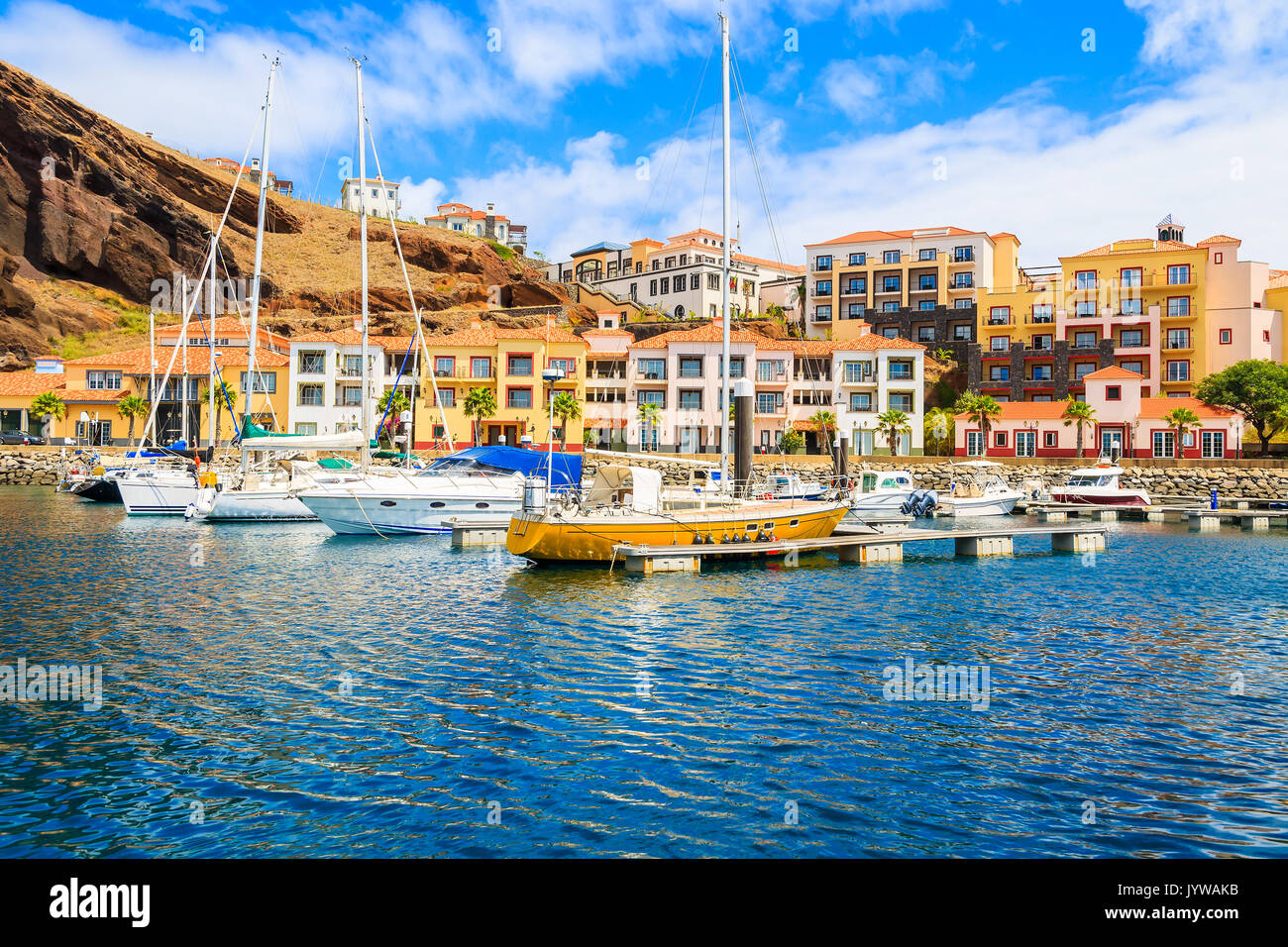 Segelboote im Jachthafen mit bunten Häusern in der Nähe von Canical Stadt an der Küste der Insel Madeira, Portugal Stockfoto