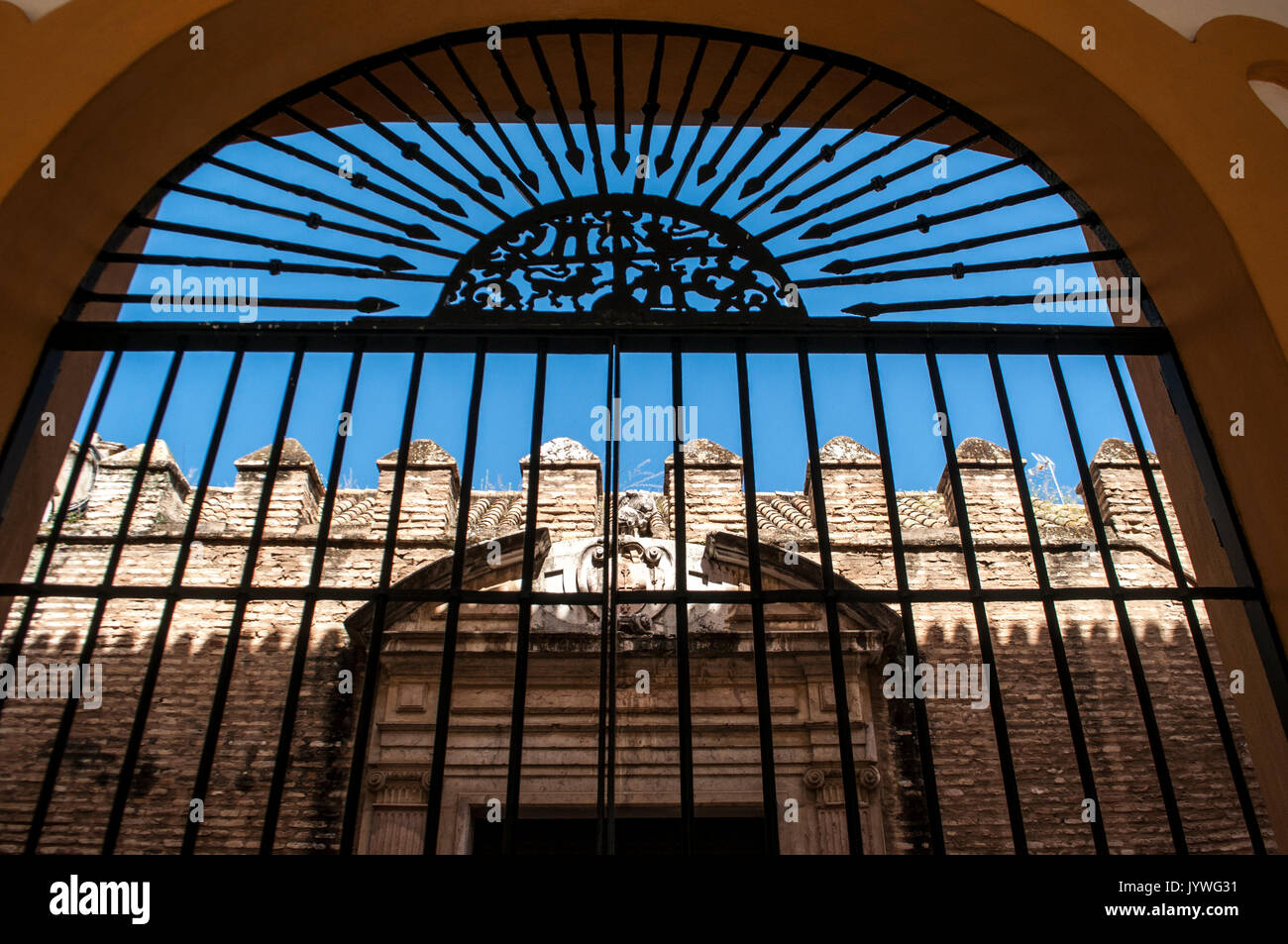 Spanien: Der Patio del Crucero, ein Hof des Alcazar von Sevilla, der königliche Palast Beispiel Mudejar Architektur, von eine Grille gesehen Stockfoto