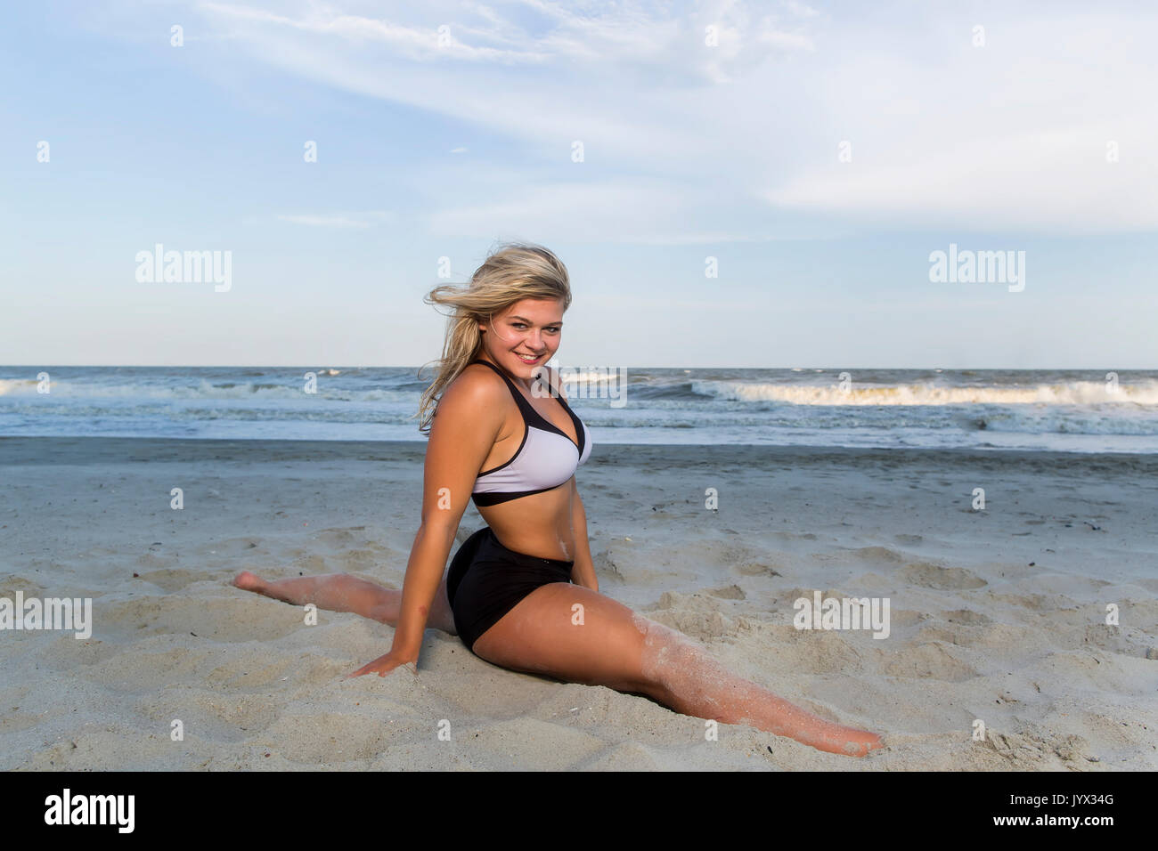 Eine schöne Blondine Teenager Modell durch den Strand arbeiten Stockfoto