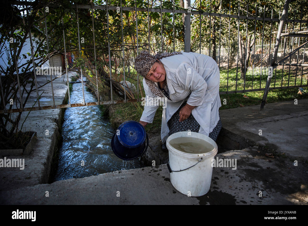 Anabar Nosirova, die als Küche Arbeiter am Beshkent Schule sammelt 80-100 Liter Wasser jeden Nachmittag beschäftigt ist. Sie filtert das Wasser durch Käse Tuch und lässt es über Nacht sitzen, damit der Staub legt sich auf den Boden. Sie kocht das Wasser, bevor der Kaffee für die Studierenden. In den Dörfern über Kirgisistan (Zentralasien) antiquierte Wasserversorgung und Infrastruktur ist die Ursache für gesundheitliche Aspekte wie Ausbrüche von Hepatitis und Erkrankungen des Magen-Darm-Trakts, besonders bei Kindern. Stockfoto