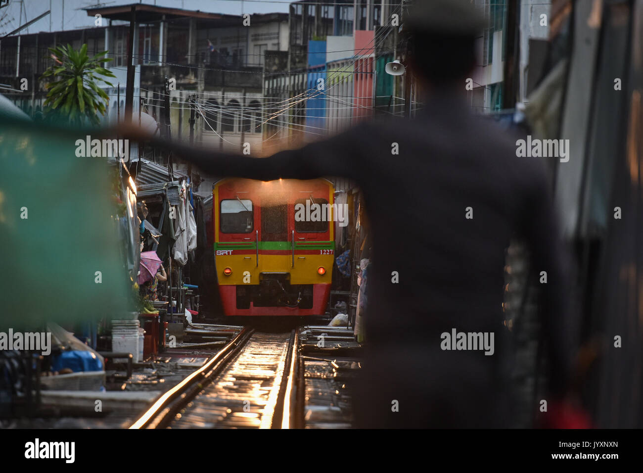 (170821) - MAEKLONG, Aug 21, 2017 (Xinhua) - der Polizist gibt Anweisungen zu einer S-Bahn durch Maeklong Markt in der zentralen Provinz Samut Songkhram Thailand, Aug 19, 2017 läuft. In Maeklong Markt, entlang einer Bahnstrecke gebaut, ein Kompromiss zwischen Anbietern und vorbei an S-Bahnen erreicht. Wenn die Rail Track ist klar, stall Besitzer bis Ständen zu werden; noch acht Mal pro Tag, die Markisen und einige der Waren haben, die von der Schiene verschoben werden und machen Weg für ankommende und abfahrende Züge. Die business Stil um Fahrpläne hat Maeklong M Stockfoto