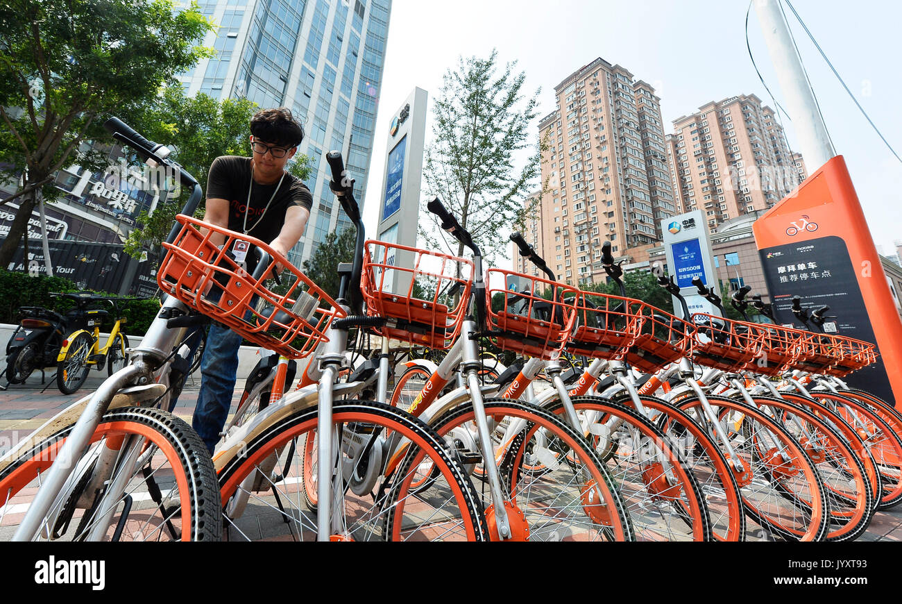 Tianjin. 21 Aug, 2017. Ein Dispatcher von gemeinsam genutzten Fahrräder stellt Fahrräder, um vor einem Einkaufszentrum in North China Tianjin, Aug 21., 2017. Trotz der glühenden Wetter in Tianjin, Dispatcher, auch als Wartung Arbeiter, Reisen quer durch die Stadt, um sicherzustellen, dass die Räder in Ordnung gebracht sind und gut funktionieren. Credit: Shi Songyu/Xinhua/Alamy leben Nachrichten Stockfoto