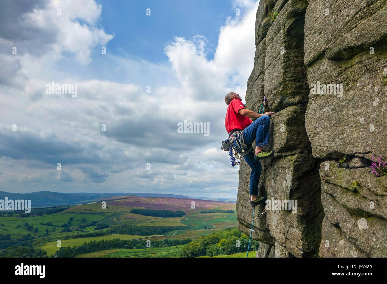 Reife männliche Kletterer im roten Hemd auf stanage Edge, Derbyshire Peak District Stockfoto