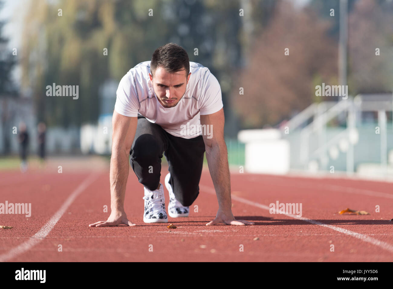 Attraktiver Mann sich bereit für das Rennen im City Park Bereich - Ausbildung und Training für Ausdauer, Fitness gesunder Lebensstil Konzept Outdoor Stockfoto