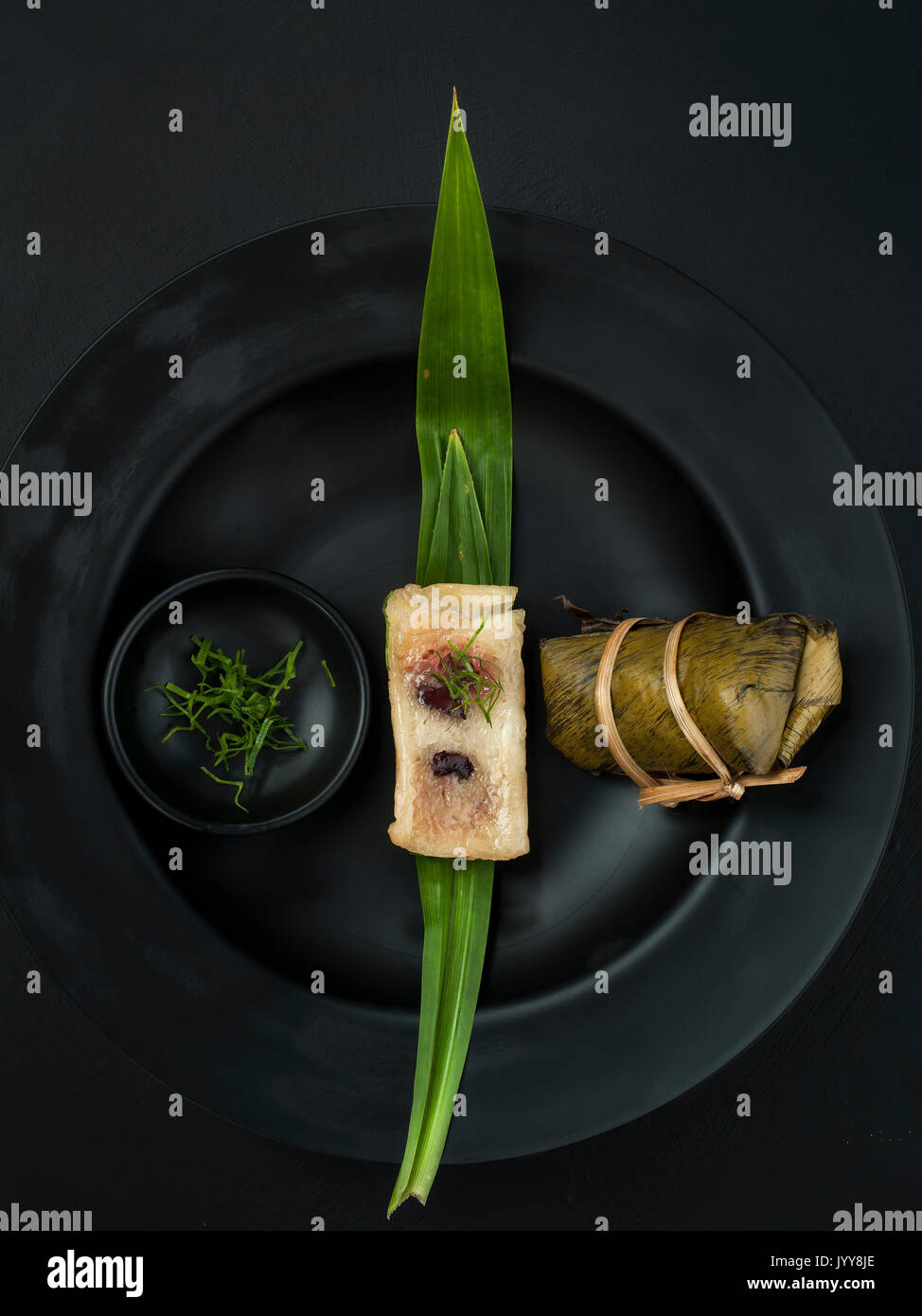 Thailändisches dessert Paar Banane in klebrigen Reis und schwarze Bohnen eingewickelt in Bananenblätter Stockfoto