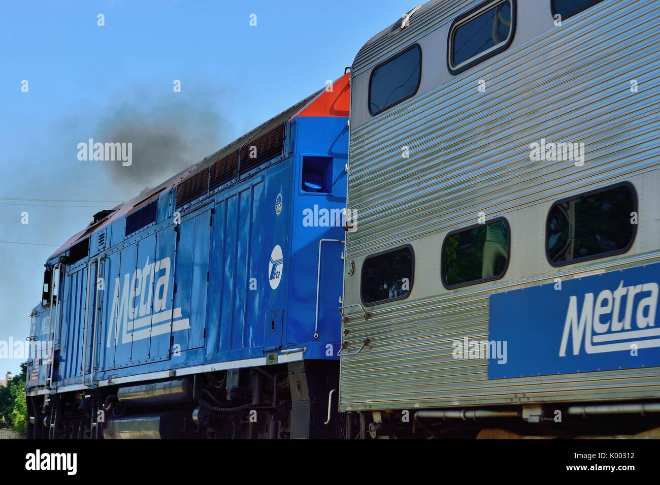 Ein Metra Pendlerzug belches, Abgase in die Luft, während die Morton Grove, Illinois Station in einem Vorort von Chicago. Illinois, USA. Stockfoto