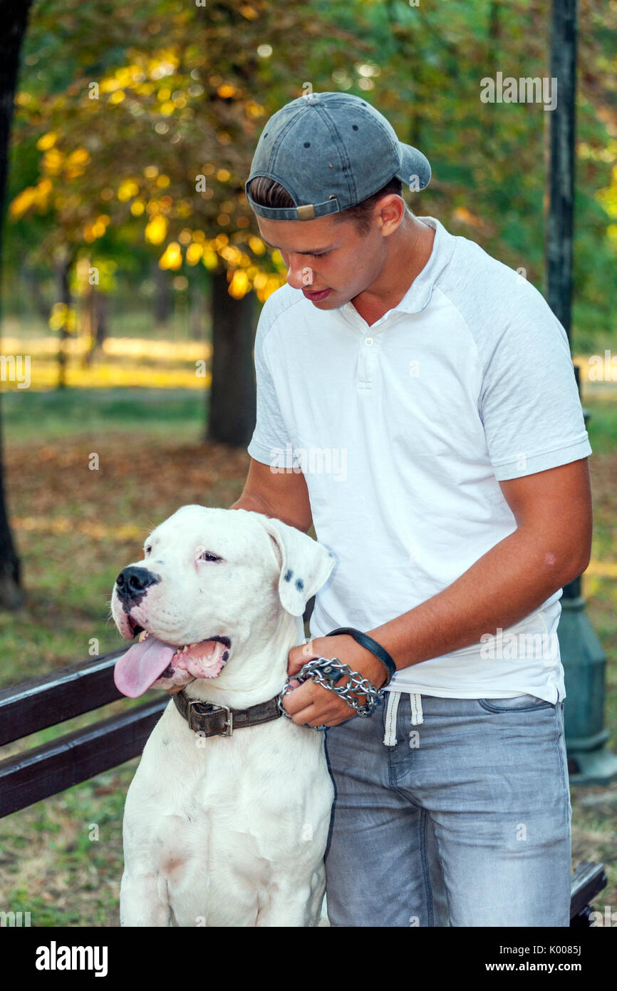 Teenager mit seinem Hund - Dogo Argentino im Park Stockfoto