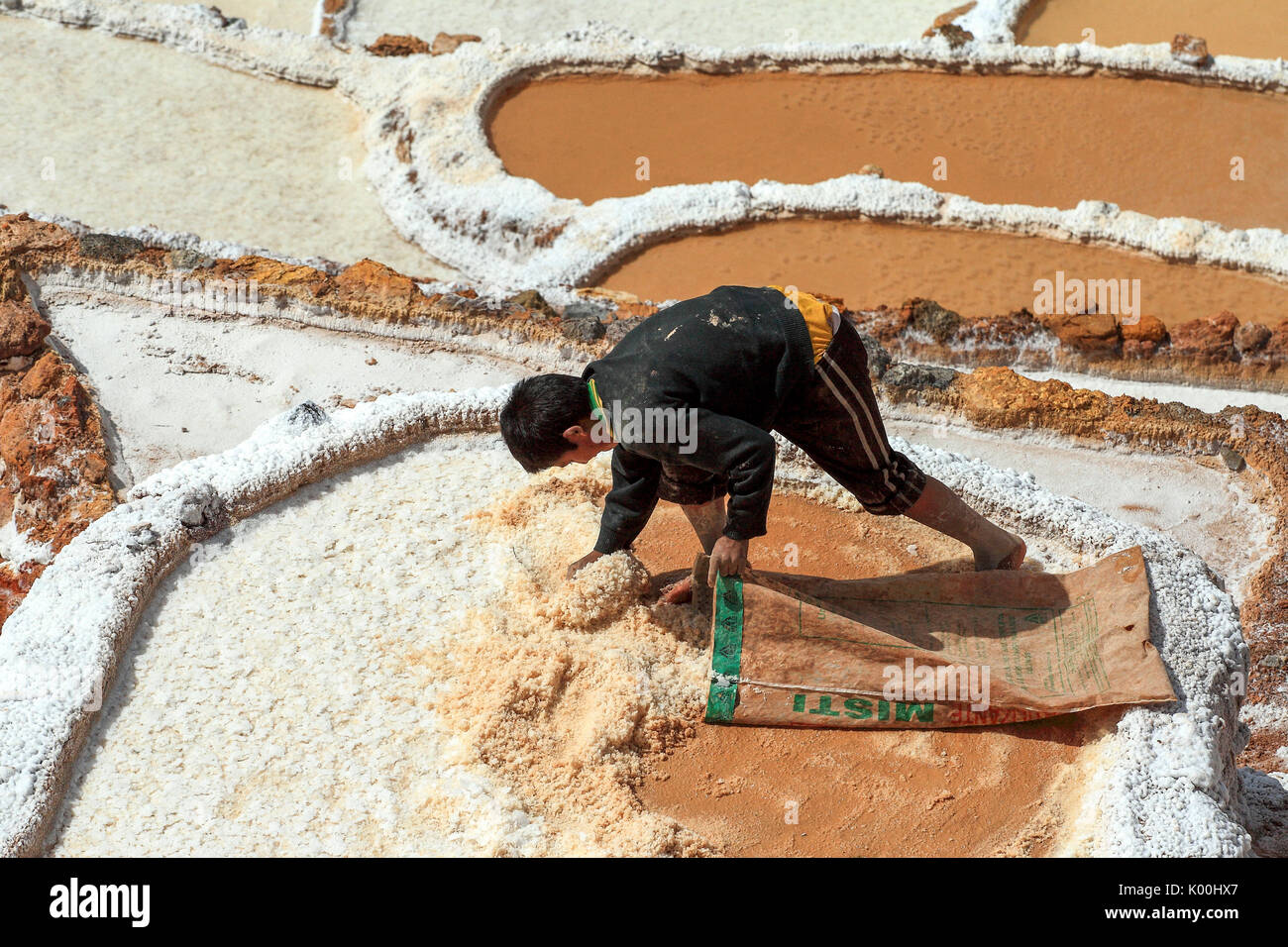 Ein junger Mann Werke der Sammlung von Salz in den Salzebenen von Maras Cusco Peru Südamerika Stockfoto