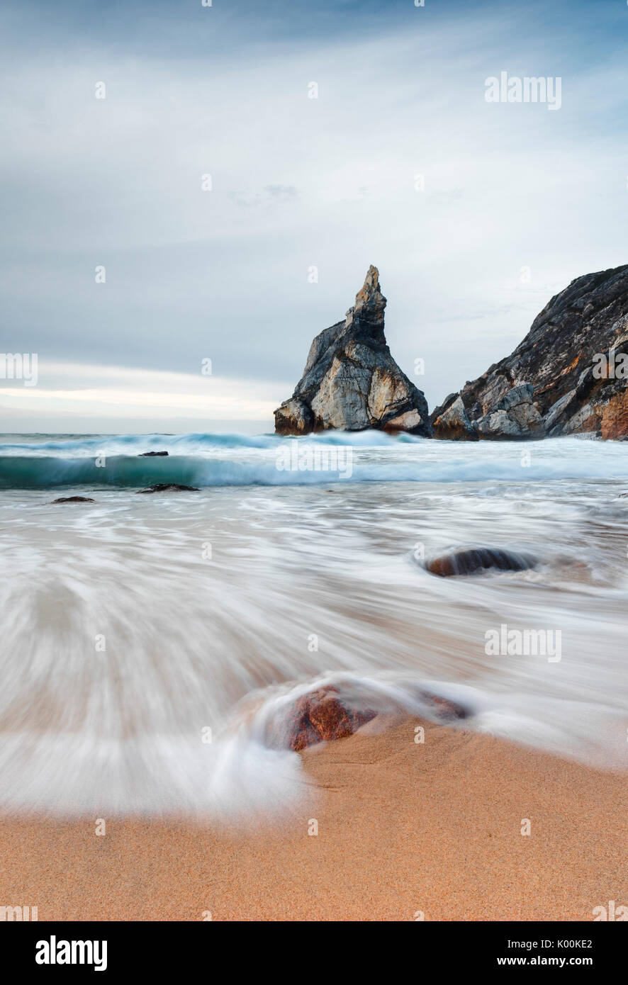 Ozean-Wellen, die auf dem sandigen Strand von Praia da Ursa umgeben von Klippen Cabo da Roca Colares Sintra Portugal Europa Stockfoto