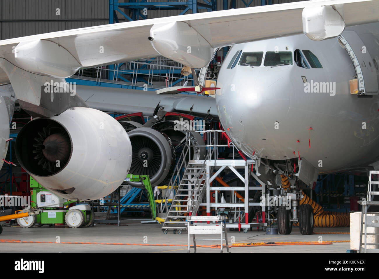 Passenger Jet Flugzeuge gewartet. in einer geschäftigen Flugzeughangar. Aviation Engineering als Faktor für die wirtschaftliche Entwicklung und das Wachstum des BIP Stockfoto