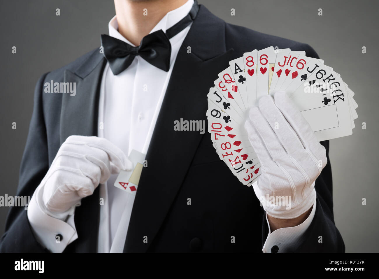 Mittelteil der Magier zeigt schwärmten aus Karten gegen grauer Hintergrund Stockfoto
