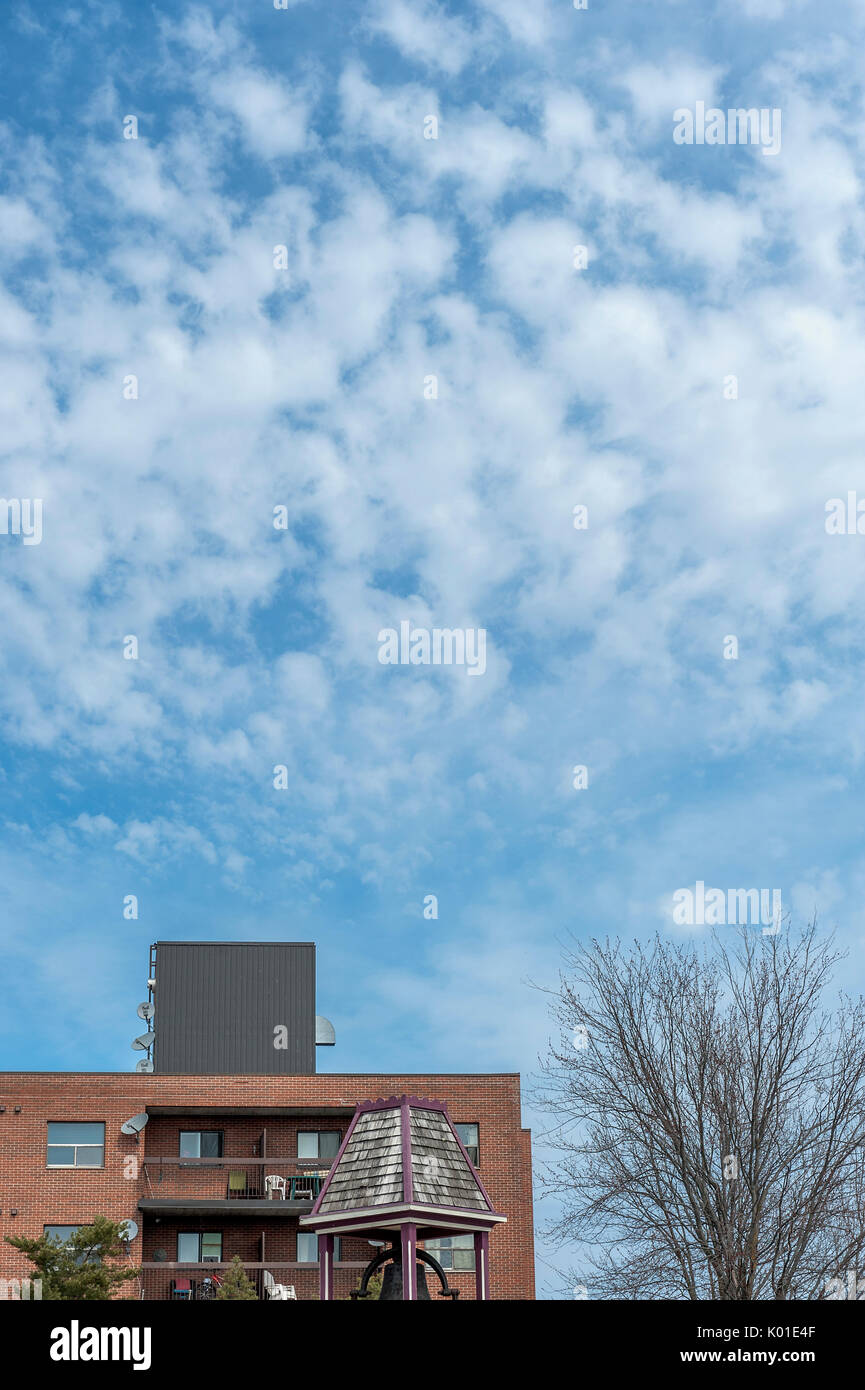 Weiße Wolken über Apartment Gebäude Stockfoto