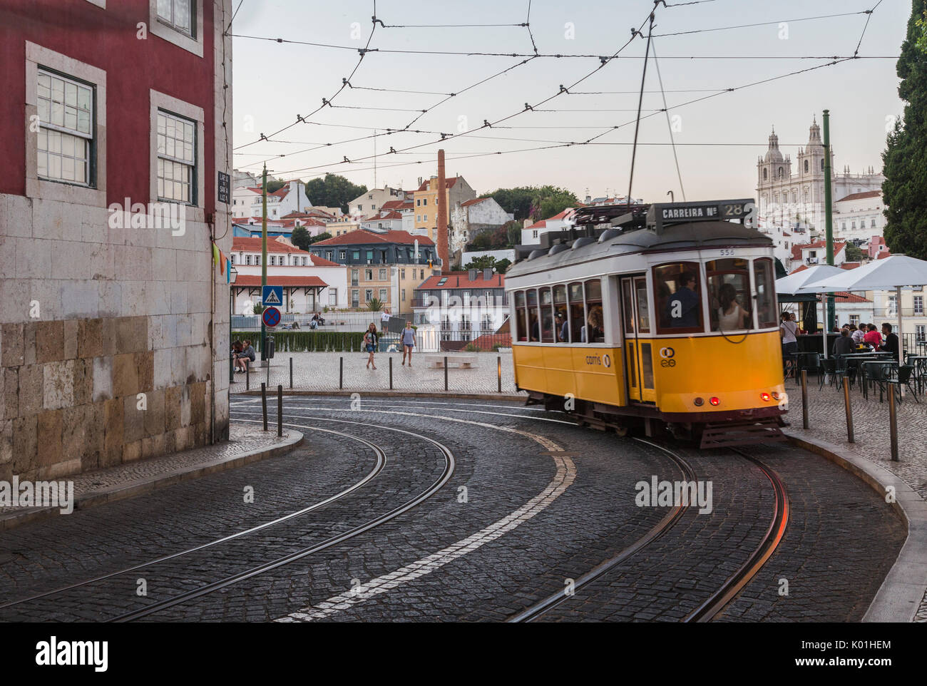 Romantische Atmosphäre in den alten Gassen der Alfama mit der Burg im Hintergrund und mit der Straßenbahn Nummer 28 Lissabon Portugal Europa Stockfoto