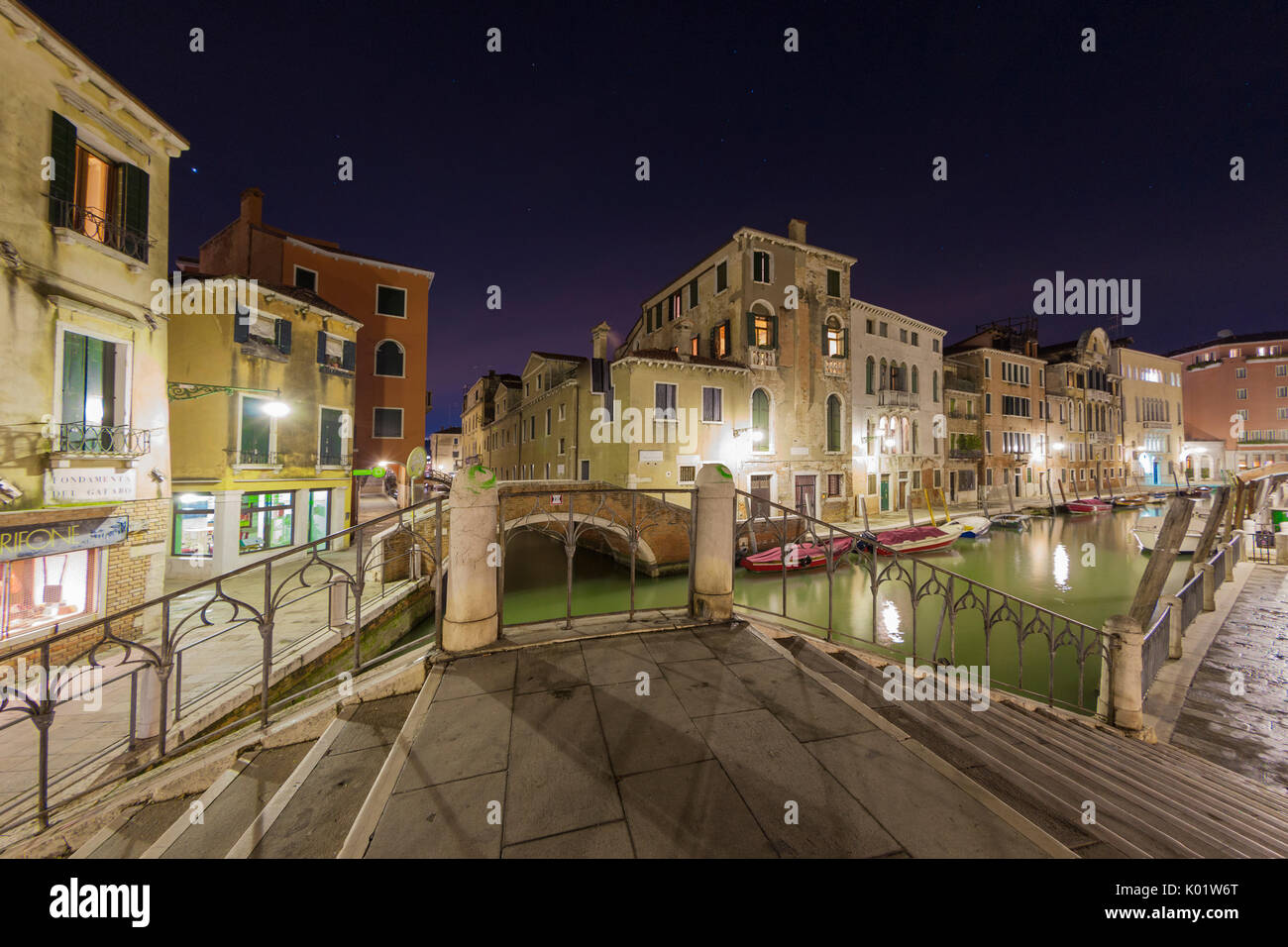 Nachtansicht der typischen Gondeln festgemacht in den Kanal, umgeben von alten Gebäuden und Brücken Venedig Veneto Italien Europa Stockfoto