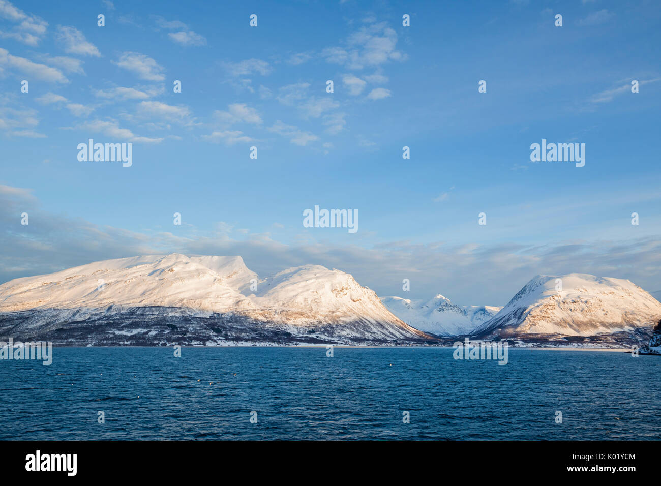 Blauen Himmel auf den schneebedeckten Gipfeln umgeben von gefrorenen Meer Olderdalen Kafjorden Lyngen Alpen Tromsø Norwegen Europa Stockfoto